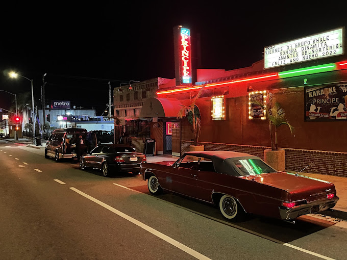 El Príncipe neon marquee at night in San Pedro with classic lowrider cars parked out front